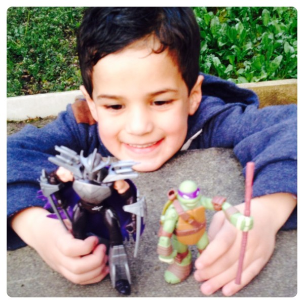 Little Man Playing with Teenage Mutant Ninja Turtles Battle Shell Figures