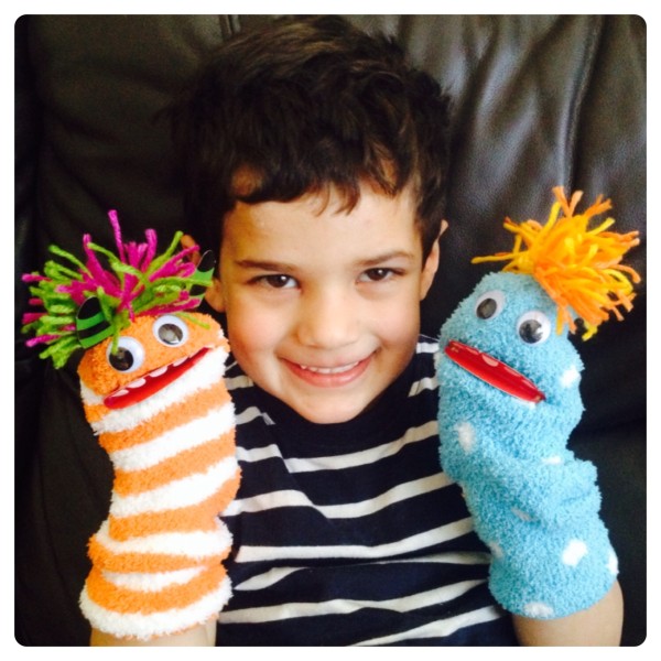 Little Man Playing with Sock Puppet Monsters